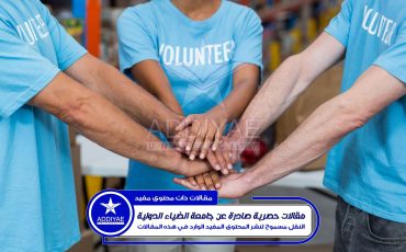 Mid section of volunteers putting hands together in a warehouse